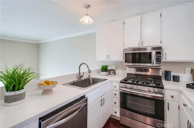 kitchen featuring appliances with stainless steel finishes, a sink, white cabinets, and ornamental molding