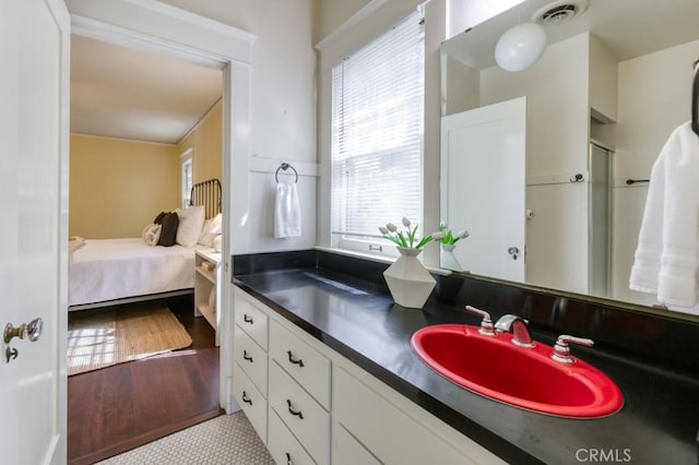 605 E Home Ave, Fresno, CA 93728 - ensuite bathroom featuring healthy amount of natural light, vanity, and wood finished floors