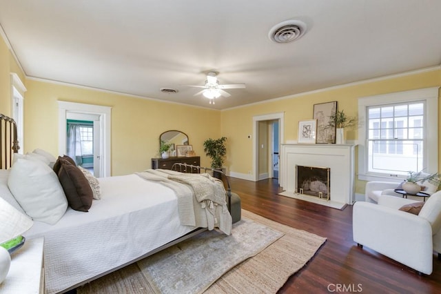 605 E Home Ave, Fresno, CA 93728 - bedroom featuring dark wood finished floors, ornamental molding, a fireplace with flush hearth, a ceiling fan, and baseboards