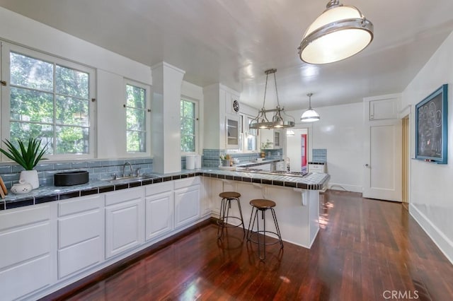 605 E Home Ave, Fresno, CA 93728 - kitchen with a sink, a peninsula, dark wood-style flooring, tile counters, and backsplash