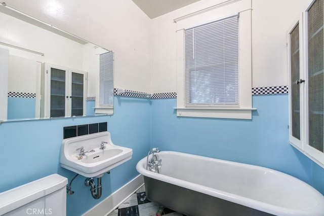 605 E Home Ave, Fresno, CA 93728 - bathroom with toilet, a freestanding tub, marble look tile flooring, and a sink