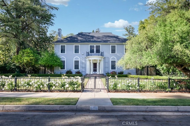 605 E Home Ave, Fresno, CA 93728 - colonial home with a fenced front yard, a gate, and stucco siding