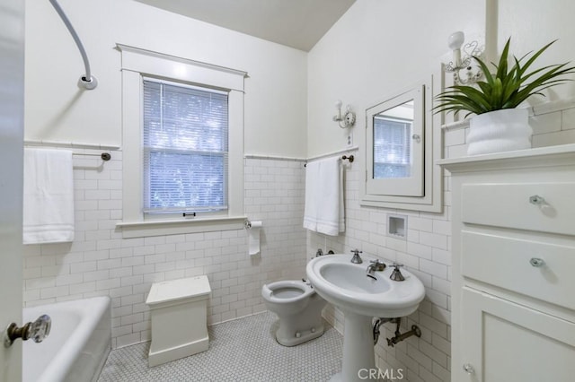 605 E Home Ave, Fresno, CA 93728 - bathroom featuring tile walls, toilet, tile patterned floors, a bathtub, and wainscoting