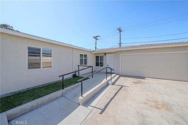 1517 W Romneya Dr, Anaheim, CA 92801 - view of front of property with stucco siding, an attached garage, and concrete driveway