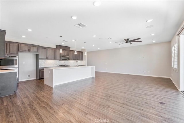 34428 Burnt Pine Rd, Murrieta, CA 92563 - kitchen featuring stainless steel microwave, light countertops, ceiling fan, decorative backsplash, and recessed lighting