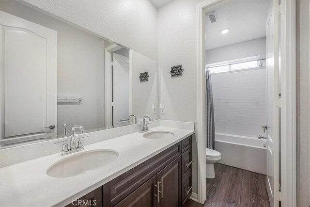 34428 Burnt Pine Rd, Murrieta, CA 92563 - full bathroom with toilet, wood finished floors, double vanity, and shower / bath combination with curtain