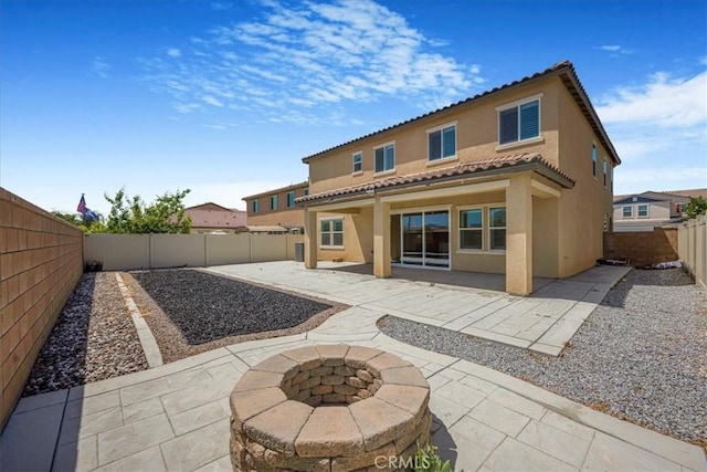 34428 Burnt Pine Rd, Murrieta, CA 92563 - back of house featuring a patio area, stucco siding, a fenced backyard, a fire pit, and a tile roof