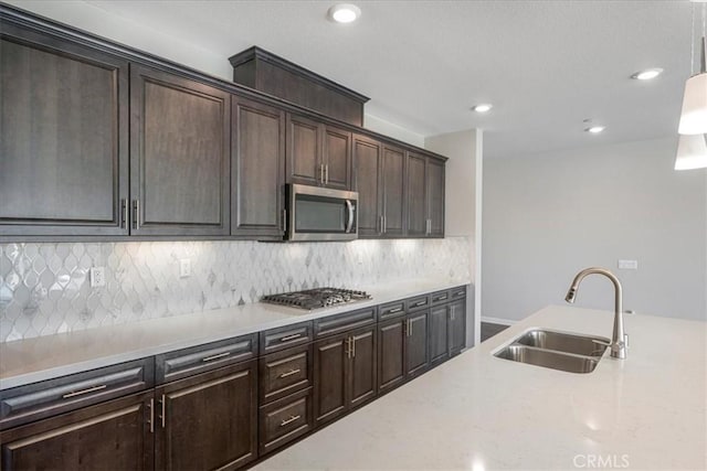 34428 Burnt Pine Rd, Murrieta, CA 92563 - kitchen with stainless steel appliances, a sink, pendant lighting, tasteful backsplash, and dark brown cabinets