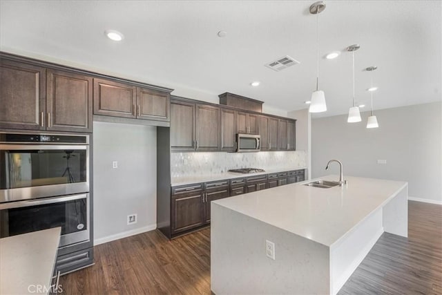 34428 Burnt Pine Rd, Murrieta, CA 92563 - kitchen featuring appliances with stainless steel finishes, a sink, baseboards, dark brown cabinets, and recessed lighting