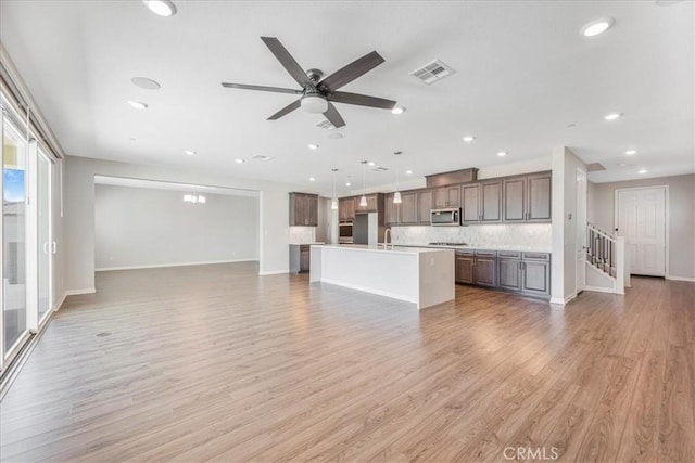 34428 Burnt Pine Rd, Murrieta, CA 92563 - unfurnished living room featuring light wood-style flooring, a sink, ceiling fan, baseboards, and recessed lighting
