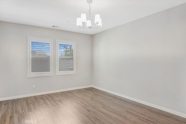 34428 Burnt Pine Rd, Murrieta, CA 92563 - empty room featuring a chandelier, wood finished floors, and baseboards