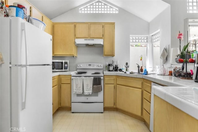 11 Avalon Unit 23, Laguna Niguel, CA 92677 - kitchen with white appliances, under cabinet range hood, vaulted ceiling, tile counters, and a sink