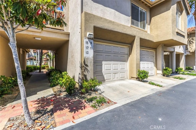 11 Avalon Unit 23, Laguna Niguel, CA 92677 - entrance to property with a garage, stucco siding, and driveway