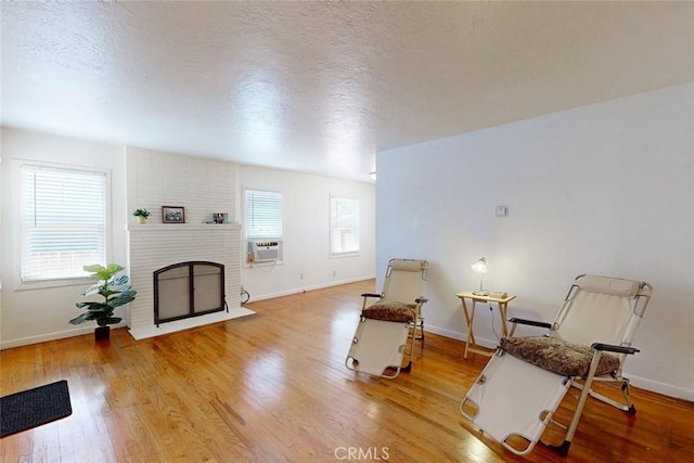 2234 Perkins Ave, Oroville, CA 95966 - living area featuring light wood finished floors, baseboards, a fireplace, and a textured ceiling