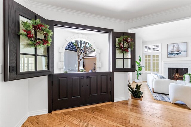 19365 Woodlands Dr, Huntington Beach, CA 92648 - entrance foyer featuring a high end fireplace, baseboards, crown molding, and wood finished floors