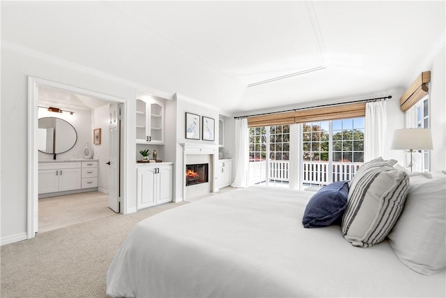 19365 Woodlands Dr, Huntington Beach, CA 92648 - bedroom featuring light carpet, access to exterior, connected bathroom, a glass covered fireplace, and crown molding