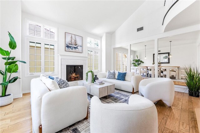 19365 Woodlands Dr, Huntington Beach, CA 92648 - living room featuring hardwood / wood-style floors, a premium fireplace, high vaulted ceiling, and baseboards