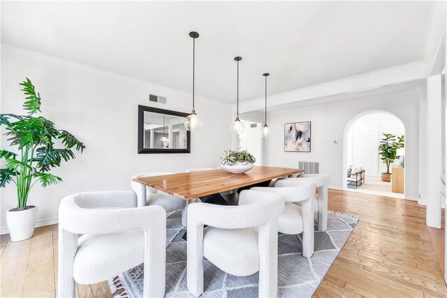 19365 Woodlands Dr, Huntington Beach, CA 92648 - dining space featuring arched walkways, light wood-type flooring, ornamental molding, and baseboards