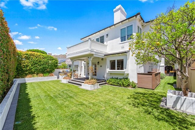 19365 Woodlands Dr, Huntington Beach, CA 92648 - rear view of property featuring a balcony, a chimney, a yard, and stucco siding