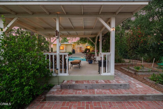 view of patio featuring a vegetable garden and a gazebo