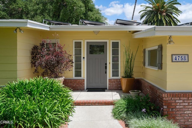 view of exterior entry featuring brick siding