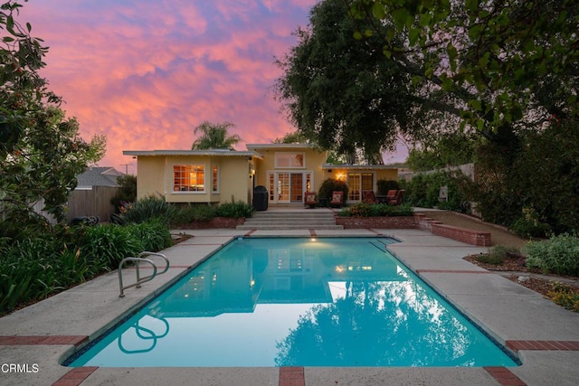 view of swimming pool with french doors and a patio area