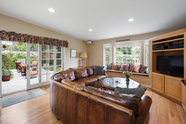 living room with light wood-type flooring and recessed lighting