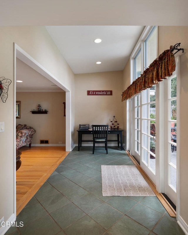 hallway with plenty of natural light, tile patterned flooring, recessed lighting, and baseboards