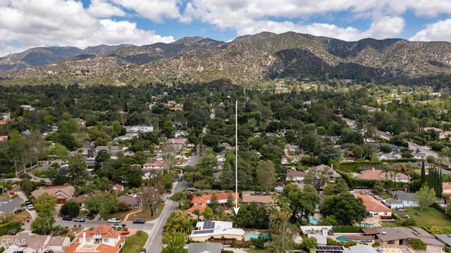 aerial view of property's location featuring a mountainous background and nearby suburban area