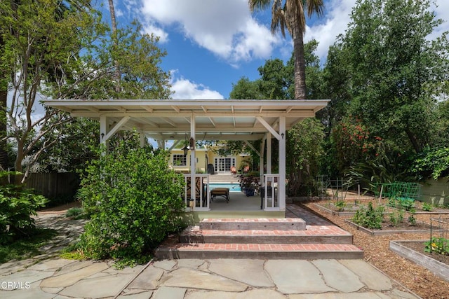 view of patio featuring a vegetable garden and fence