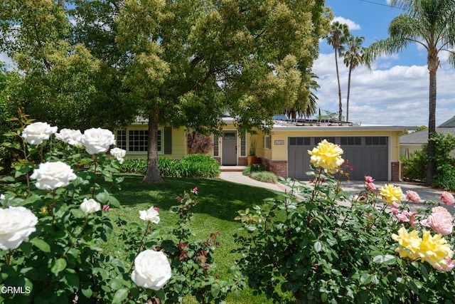 view of front of house with brick siding, a garage, concrete driveway, and a front lawn