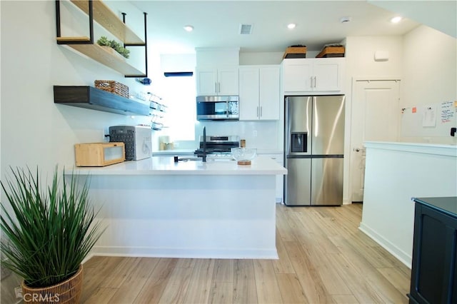 1567 Lima Way Unit 4, Placentia, CA 92870 - kitchen featuring appliances with stainless steel finishes, open shelves, a peninsula, light wood-type flooring, and recessed lighting
