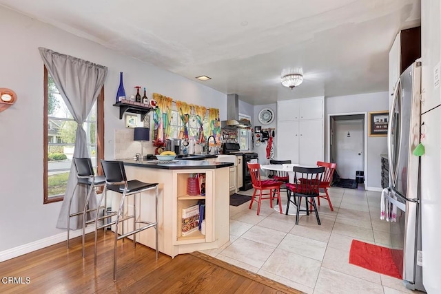 1065 Nithsdale Rd, Pasadena, CA 91105 - kitchen featuring freestanding refrigerator, black gas stove, open shelves, wall chimney exhaust hood, and dark countertops