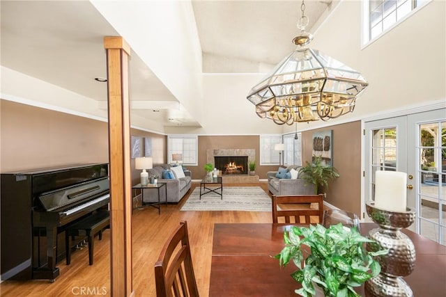 5642 Burlingame Ave, Buena Park, CA 90621 - dining area with wood finished floors, a lit fireplace, french doors, a high ceiling, and a chandelier