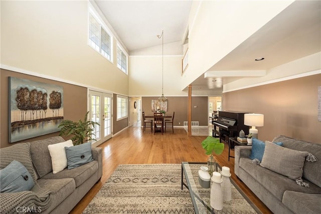 5642 Burlingame Ave, Buena Park, CA 90621 - living room featuring light wood-style flooring, baseboards, a chandelier, and a towering ceiling