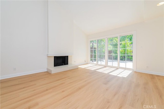 29355 Shell Cv, Laguna Niguel, CA 92677 - unfurnished living room featuring baseboards, a brick fireplace, wood finished floors, and high vaulted ceiling
