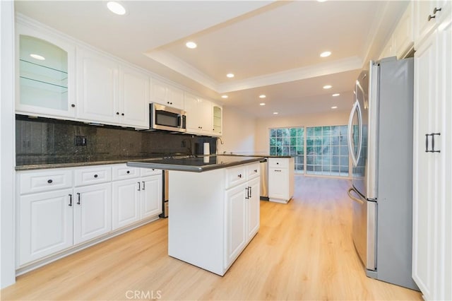 29355 Shell Cv, Laguna Niguel, CA 92677 - kitchen with stainless steel appliances, light wood-type flooring, a raised ceiling, dark countertops, and white cabinets