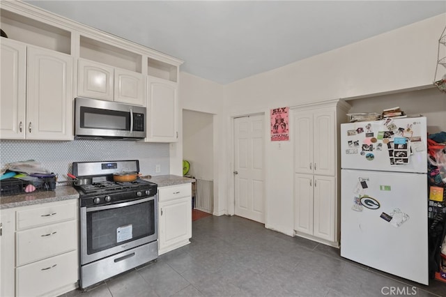 2580 Ganahl St, Los Angeles, CA 90033 - kitchen featuring appliances with stainless steel finishes, white cabinetry, tasteful backsplash, and dark tile patterned floors
