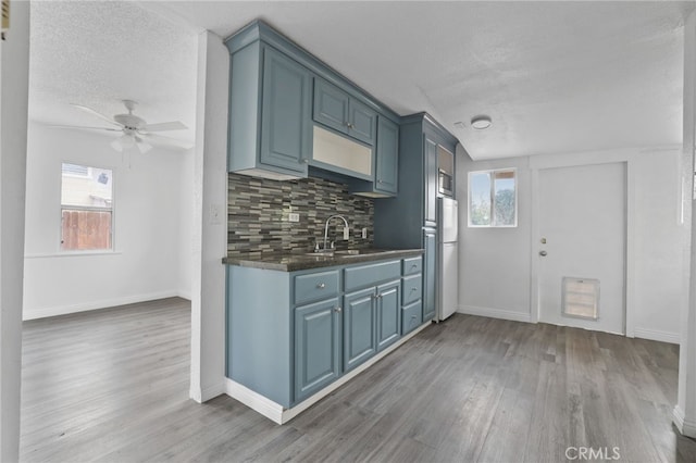 2580 Ganahl St, Los Angeles, CA 90033 - kitchen featuring a sink, a textured ceiling, wood finished floors, freestanding refrigerator, and dark countertops
