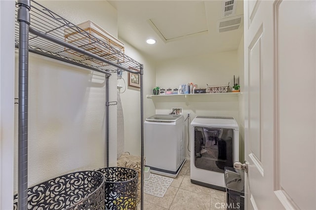 clothes washing area with washer and clothes dryer, light tile patterned floors, and recessed lighting
