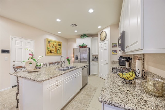 kitchen featuring a sink, stainless steel appliances, an island with sink, light tile patterned floors, and recessed lighting