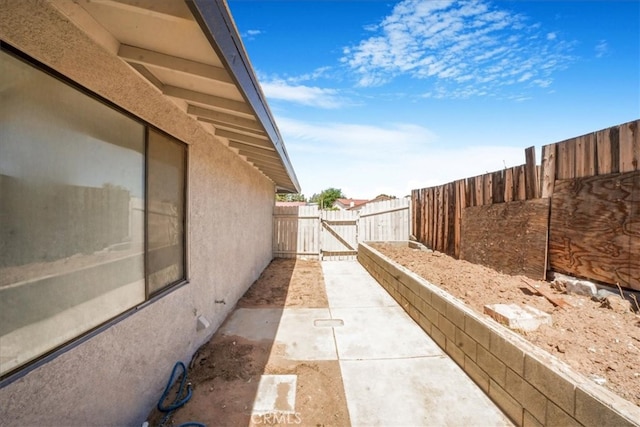 14351 Cronese Rd, Apple Valley, CA 92307 - view of property exterior featuring stucco siding, fence, a gate, and a patio