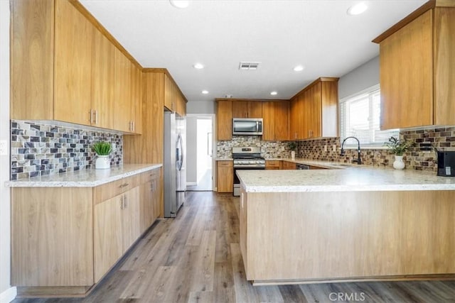 14351 Cronese Rd, Apple Valley, CA 92307 - kitchen featuring stainless steel appliances, a sink, a peninsula, decorative backsplash, and light wood finished floors