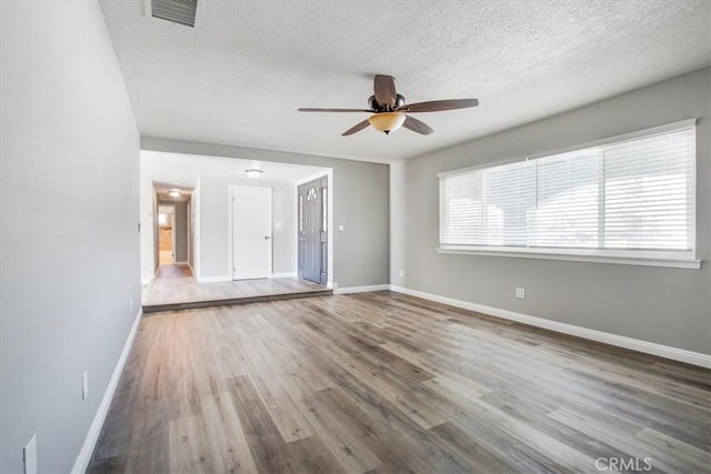 14351 Cronese Rd, Apple Valley, CA 92307 - unfurnished living room with ceiling fan, wood finished floors, baseboards, and a textured ceiling