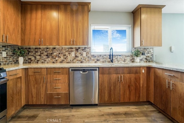 14351 Cronese Rd, Apple Valley, CA 92307 - kitchen with stainless steel dishwasher, a sink, light stone counters, wood finished floors, and decorative backsplash