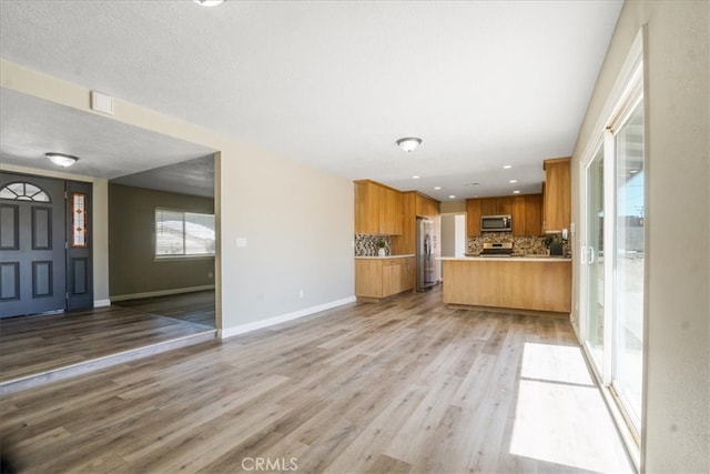 14351 Cronese Rd, Apple Valley, CA 92307 - kitchen with stainless steel appliances, open floor plan, light countertops, decorative backsplash, and light wood finished floors