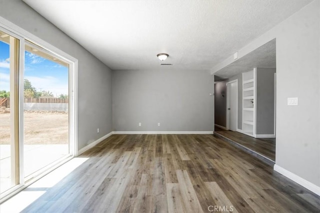 14351 Cronese Rd, Apple Valley, CA 92307 - unfurnished room featuring wood finished floors, baseboards, and a textured ceiling