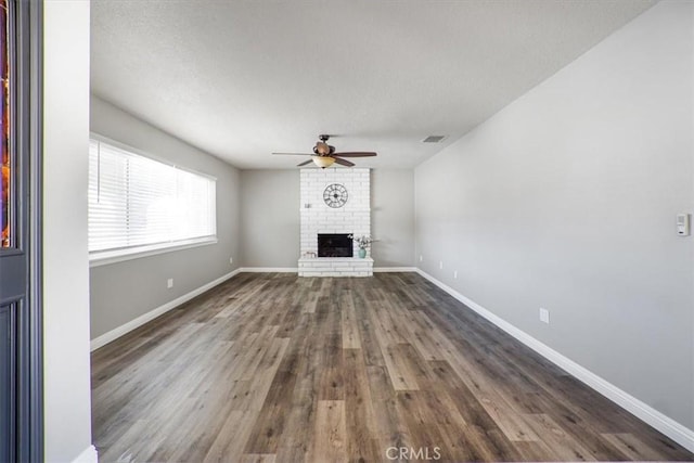 14351 Cronese Rd, Apple Valley, CA 92307 - unfurnished living room with a ceiling fan, a brick fireplace, dark wood finished floors, and baseboards
