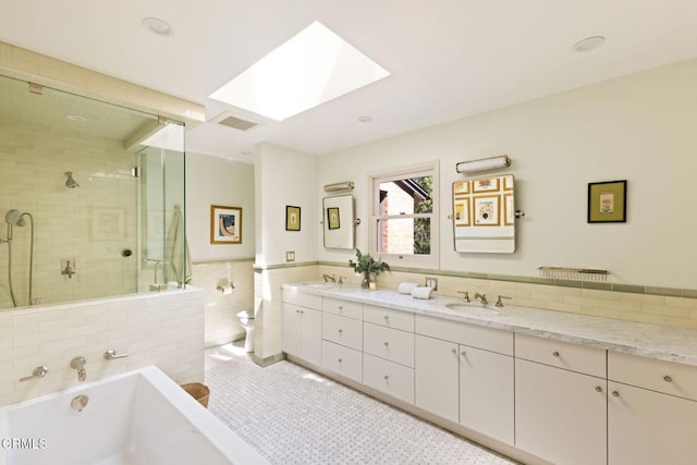 1555 Scenic Dr, Pasadena, CA 91103 - bathroom featuring a skylight, double vanity, a tub to relax in, a shower stall, and tile walls