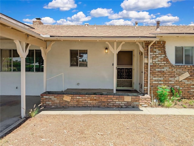 11674 Oak Ln, Yucaipa, CA 92399 - property entrance with brick siding, stucco siding, a shingled roof, and a chimney